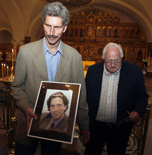 Peter Klebnikov holds a portrait of his slain brother at a service in Moscow. The Klebnikovs’ uncle, Arkady Nebolsin, stands beside him. (AP/Mikhail Metzel )