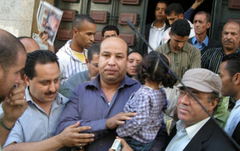 Driss Chahtan holds his daughter while being taken to prison. (Abdelwahid Mahir)