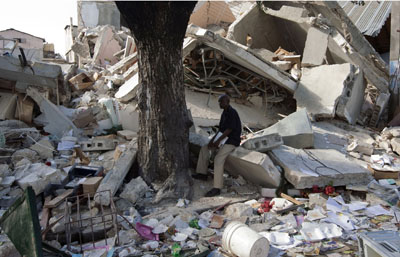 A man sits amid the rubble in Port-au-Prince. (AP)