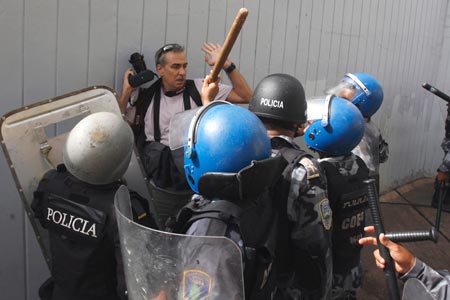 Honduran police surround AP photographer Dario Lopez-Mills as he covers protests that followed the June presidential coup. (Reuters/Oswaldo Rivas)