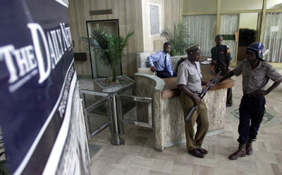 Armed riot police and security officers guard the entrance to The Daily News after it was shut down in 2003. It may soon reopen. (AP)