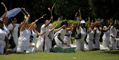 The Ladies in White, wives and mothers of Cuban political prisoners, kneel outside a Havana church on Sunday. (AP/Javier Galeano)