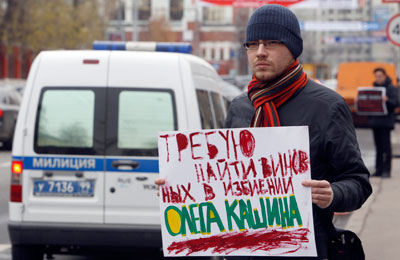 A man holds up a placard pressing for a thorough investigation into the beating of Oleg Kashin. (Reuters/Sergei Karpukhin)