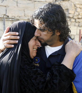 Iraqi photographer Ibrahim Jassam hugs his mother as he returns home after 17 months in U.S. custody. He was never charged with a crime. (Reuters/Thaier al-Sudani)