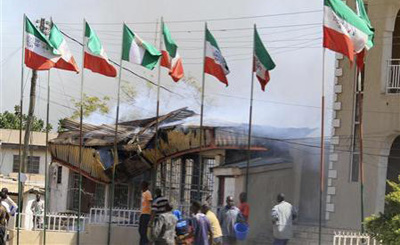 Since December 24, about 80 people have died from three bombings in Jos; seen here is a government building smoldering after a blast. (Reuters)