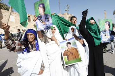 Libyan pro-government supporters hold posters of Libyan leader Muammar Qaddafi during a demonstration in Tripoli. (Reuters/Ismail Zitouny)