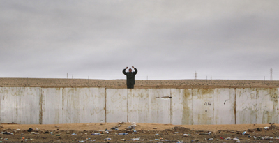 A pro-Qaddafi fighter raises his fists as a bus carrying journalists passes by during a government-organized visit for foreign media southeast of the capital Tripoli today. (AP/Ben Curtis)