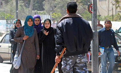A Hamas policeman orders a group of students to disperse after they attempted to gather for a protest in Gaza City. (AP/Hatem Moussa)