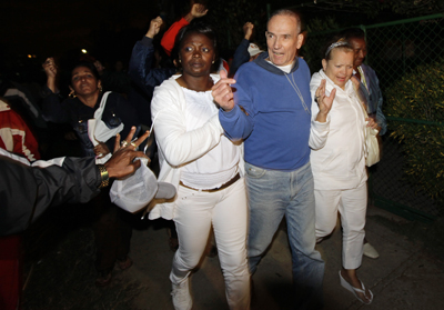 Héctor Maseda Gutiérrez walks free with his wife (right), while followed by government supporters jeering his release. (Reuters/Desmond Boylan)