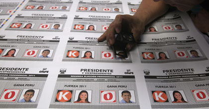 A worker inspects ballots with images of presidential candidates in Peru. (AP/Martin Mejia)