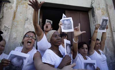 In Cuba, the Ladies in White were instrumental in drawing attention to the plight of political prisoners. Here, they hold a photo of Orlando Zapata Tamayo, who died in custody. (AP/Javier Galeano)
