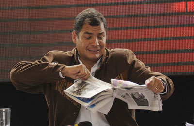 President Rafael Correa rips a copy of the  national daily La Hora during a conference in Cotacachi County. Correa has taken an aggressive stance toward news media. (El Universo)
