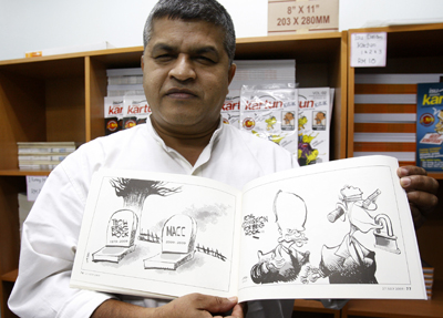 Zunar displays a copy of his previously banned cartoons. (AP)