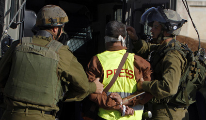 الصحفيين الذين يغطون الاحتجاجات والاضطرابات المدنية يواجهون خطر الاعتقال المتزايد. في هذه الصورة جنود إسرائيليين يعتقلون صحفيا فلسطينيا. (رويترز)