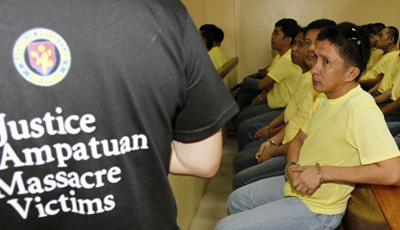 An advocate for the Maguindanao massacre victims appears at a court hearing near several police officers charged in the killings. (Reuters/Romeo Ranoco)