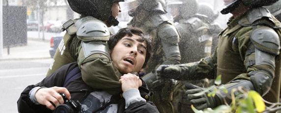 La policía detiene a un fotógrafo durante manifestaciones contra el gobierno en Santiago. (Reuters/Carlos Vera)