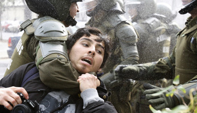 Police in Santiago seize a photographer during an anti-government demonstration. (Reuters/Carlos Vera)