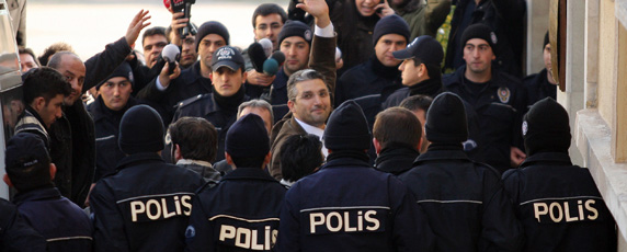 Behind a wall of police, Turkish writer Ahmet Şik arrives at a courthouse in Istanbul to face antistate charges.   (Reuters)