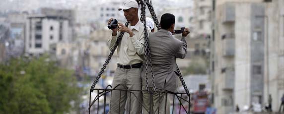 Perchés au sommet d'une grue surplombant une manifestation, des journalistes filment les foules dans la ville yéménite de Taiz. (Reuters / Khaled Abdullah)