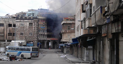 Smoke rises from a building in a Homs neighborhood. The city has been shelled daily for three weeks. (Reuters)