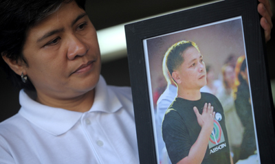 The wife of Philippines journalist Gerardo Ortega looks at his picture. (AFP/Noel Celis)