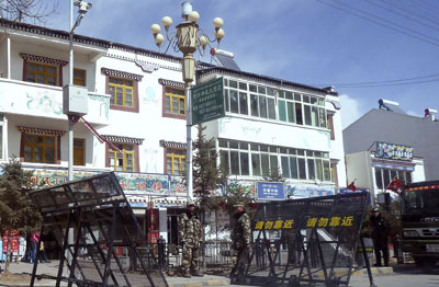 In this photo taken February 27, Chinese paramilitary and riot police stand guard near barricades set up along the main street of a Tibetan monastery town in Sichuan province. (AP/Gillian Wong)