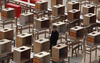 A villager stands near ballot writing booths at a school playground in Wukan village in Guangdong province Friday, one day before the election of a seven-member village committee. (Reuters/Bobby Yip)