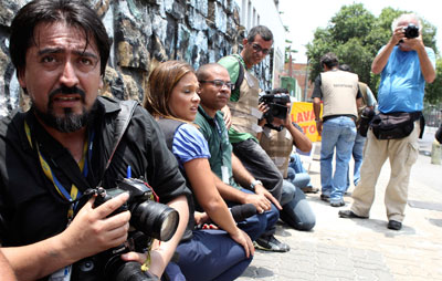 Jornalistas se protegem durante operação policial contra traficantes de drogas no Rio de Janeiro. (Reuters/Sergio Moraes)