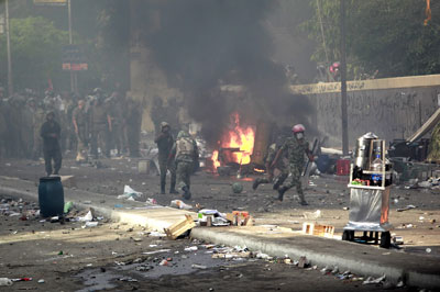 Security forces throw stones back at protesters in Cairo on Friday. Thousands marched to denounce violence against demonstrators and the exclusion of candidates from the presidential election. (Reuters)