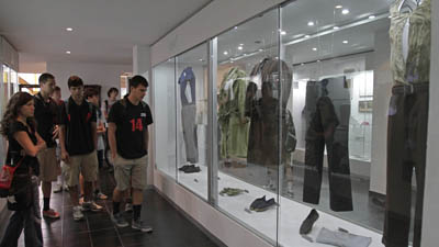 Visitors look at an exhibit displaying the bloodstained clothes of the Jesuit priests murdered by the Salvadoran military in 1989. (AP/Luis Romero)