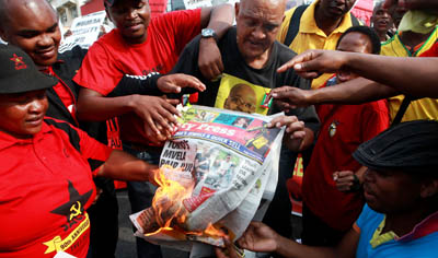 Protesters burn a copy of the City Press newspaper. (AFP/Rajesh Jantilal)