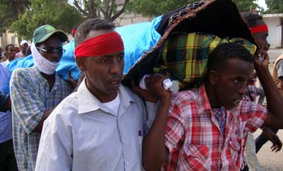 Des journalistes Somaliens portent le corps de Abdisalan Sheikh Hassan qui travaillait pour la chaine Horn Cable TV et a été tué en décembre 2011. Peur de la violence est une des raisons qui poussent le plus les journalistes en exil. (AFP/Mohamed Abdiwahab)