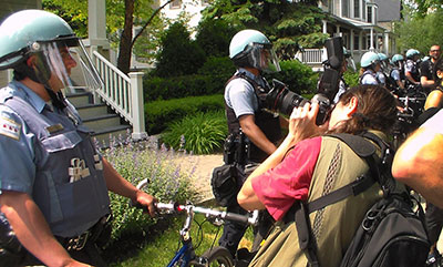 A journalist photographs at a protest against the NATO Summit in May 2012 in front of Chicago Mayor Rahm Emanuel's home. (Mickey H. Osterreicher)