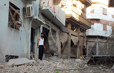 Syrian residents inspect houses destroyed by what they say was heavy shelling from government forces in Homs on Tuesday. (Reuters/Yazan Homsy)