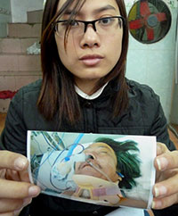 Blogger Trinh Kim Tien shows a photo of her father after he was beaten by police. (AFP/Ian Timberlake)