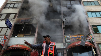 Firefighters extinguish a blaze on the tower housing local and international media on the Gaza Strip. (AFP/Mahmud Hams)