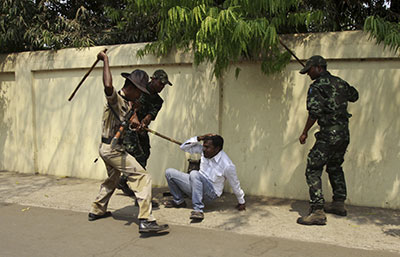 Indian policemen beat an opposition activist during a protest outside the Odisha state chief minister's office in Bhubaneswar, India, on March 25. (AP/Biswaranjan Rout)