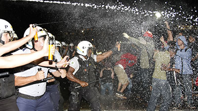 At least 25 journalists have been attacked during clashes between demonstrators and police in Brazil. Here, police in Brasilia spray protesters with pepper gas during a demonstration. (AFP/Beto Barata)