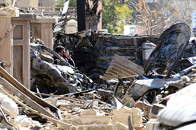 A journalist photographs damage from twin bomb attacks in Damascus. (AFP/Louai Beshara)