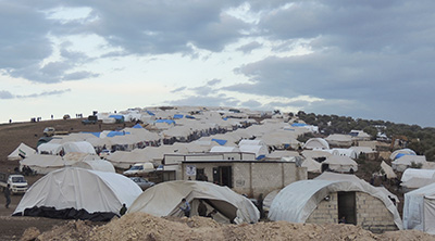 سوريون لجأوا إلى مخيم لاجئين قرب الحدود التركية. (رويترز/ محمد نجدت قدور/ شبكة شام الإخبارية)