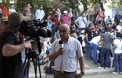 A TV journalist reports on the protests in Istanbul. Several journalists have been targeted while covering the clashes in the country. (AP/Kostas Tsironis)