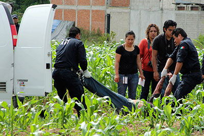 Police remove the body of Alberto López Bello, a crime reporter, from a crime scene in Oaxaca on July 17. (Reuters/Jorge Luis Plata)