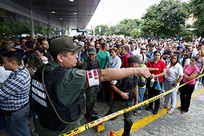 Shoppers flock to stores after the government orders business owners to lower prices. (Reuters/Carlos Garcia Rawlins)