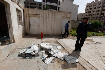 An Iraqi journalist stands near archive newspapers burned when an armed group attacked Addustour newspaper in Baghdad on April 2. Iraq has an appalling record of not prosecuting attacks on journalists. (Reuters/Thaier al-Sudani)