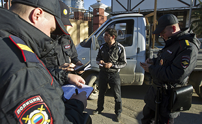 Сотрудники полиции проверяют водительское удостоверение на посте регулирования движения. (Reuters/Maxim Shemetov)