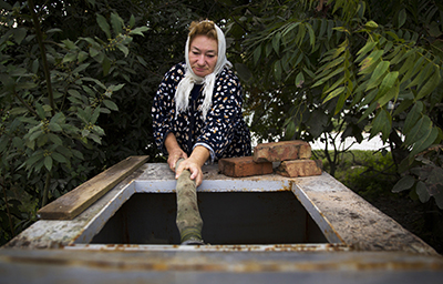 Женщина берёт недельный рацион воды в Сочи. С момента начала олимпийской стройки многие колодцы в Сочи опустели. (Reuters/Thomas Peter)
