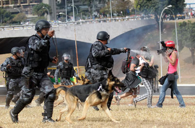 A police officer aims pepper spray at photographers during a protest in September 2013. (Reuters/Ueslei Marcelino)