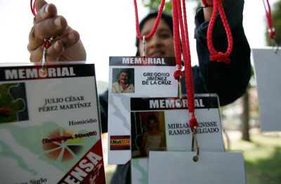 En una protesta realizada en la ciudad de Guadalajara el 23 de febrero del 2014, una manifestante porta las credenciales de periodistas que han sido asesinados en los últimos años en México. (Reuters/Alejandro Acosta)