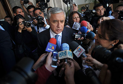 President Pérez Molina is surrounded by journalists in Guatemala City. Some media outlets claim his government has shut them out of coverage. (AFP/John Ordonez)