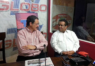 Globo TV host Aníbal Barrow, pictured right, interviewing a presidential candidate, was murdered in 2013. (AFP)